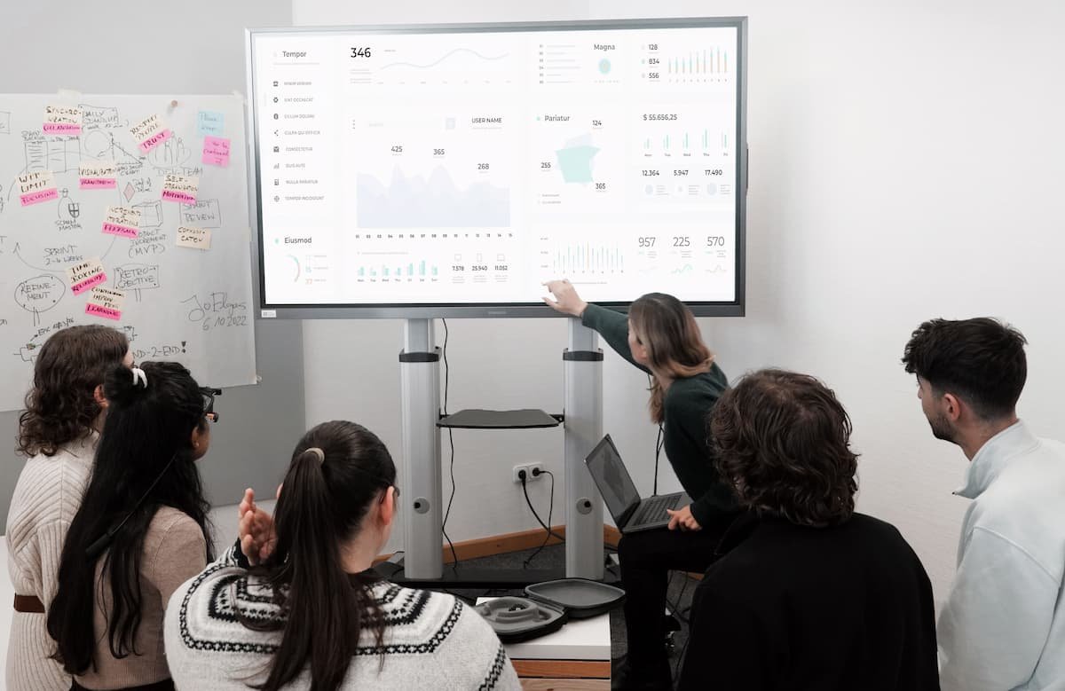 Team reviewing data on screens, illustrating AI in BPO and automated outsourcing workflows